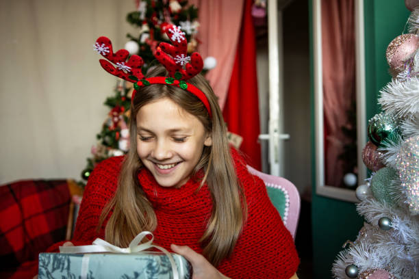 istock Beautiful teenage girl holding Christmas present 1359979607