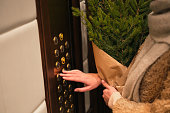 a young beautiful woman bought a Christmas tree and is taking it home in the elevator. woman with fir branches climbs in the elevator christmas mood