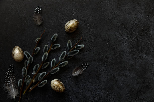 istock Happy Easter concept. Preparation for holiday. Golden decorated easter eggs willow feather on trendy grunge scratched dark black shale background. Simple minimalism flat lay top view, copy space 1359983858