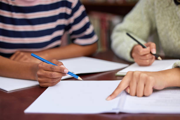 istock Shot of two unrecognizable students studying in a library 1359984016