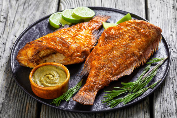 two fried ocean perch with rosemary and lime two roasted sea perches on a plate with rosemary and lime slices, close-up sebastinae photos stock pictures, royalty-free photos & images