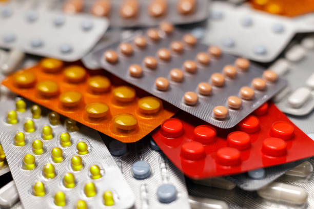 groupe de capsules colorées et pilules avec des cloques - pill vitamin b vitamin pill orange photos et images de collection