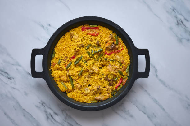 istock rice and rabbit paella with peppers on a white marble background 1359984525