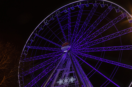 abstract colorful background with a circle of ferris wheels on a dark sky in the sity market