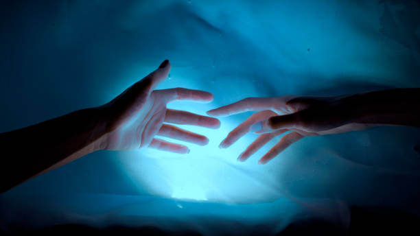 istock Hands dancing with shadows and light. Soft and shy touches 1359986643