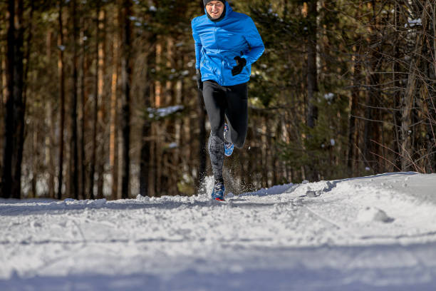istock male runner running on snowy trail in forest 1359986925
