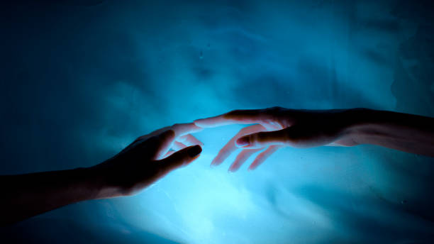 istock Hands dancing with shadows and light. Soft and shy touches 1359988125