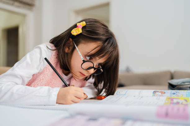 fazendo lição de casa - child glasses elementary student reading - fotografias e filmes do acervo