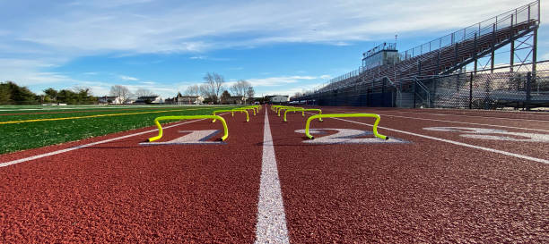 istock Looking down the track at yellow mini hurdles in two lanes 1359992395