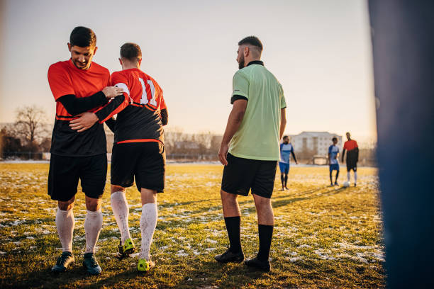 Soccer players substitution Group of people, male soccer match on a soccer field on winter day outdoors. Reserve player is getting in a game. soccer team captain stock pictures, royalty-free photos & images