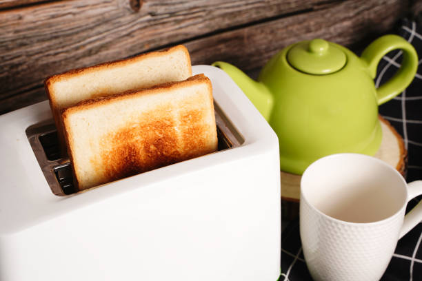 istock Toaster with bread slices and cup of coffee on table 1359995830