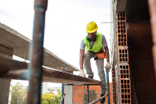 istock Construction worker climbing on scaffolding at building site 1359996789