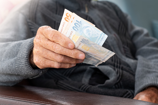 Hombre mayor arrugado de manos sosteniendo billetes de lira turca. Concepto de crisis monetaria financiera photo