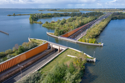 The Veluwemeer Aqueduct carries a small stretch of a lake over a road and allows for boats and vessels to pass over the motorway in the Netherlands