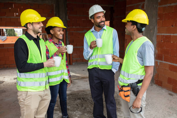 istock Group of multiracial construction workers having coffee break at site 1359998440
