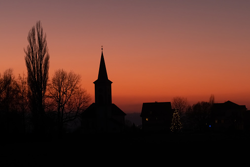 Sunset silhouette of the idyllic village of Busskirch  on the shores of the Upper Zurich Lake (Obersee), Rapperswil-Jona, St. Gallen, Switzerland
