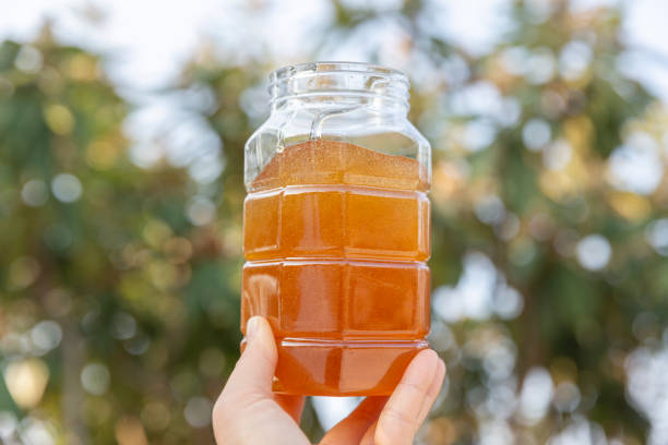 istock A woman’s hand holding a jar of honey 1359999563