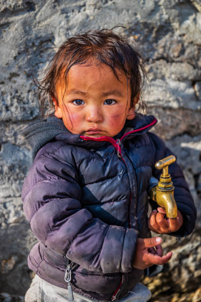 menina nepalês brincando com uma torneira de água, parque nacional do monte everest, nepal - indian culture child little girls indigenous culture - fotografias e filmes do acervo