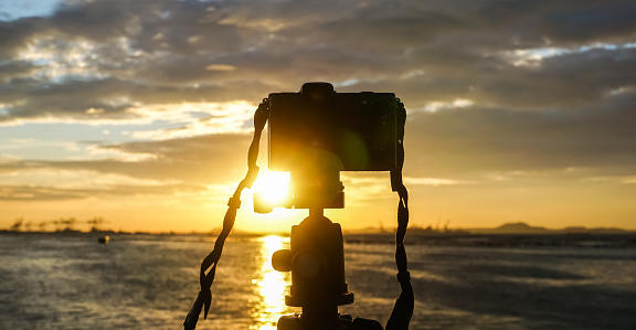 Take photography, Silhouette of camera with sunset sky at sea