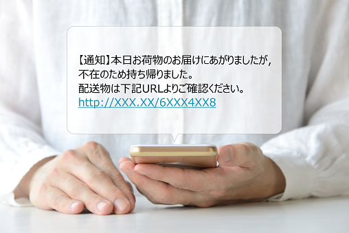 Woman looking at smart phone with scam mail message in Japanese