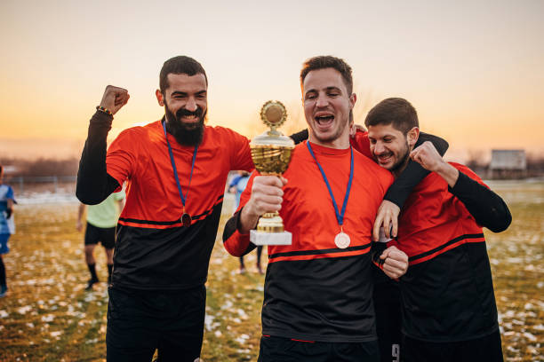 istock Football team celebrating a trophy 1360003739