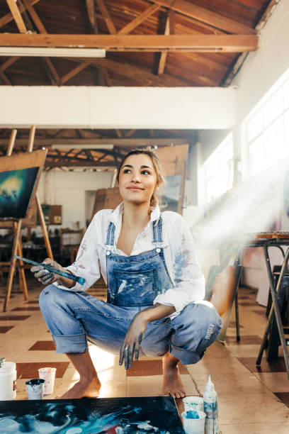istock Pensive young painter squatting on the floor 1360006564
