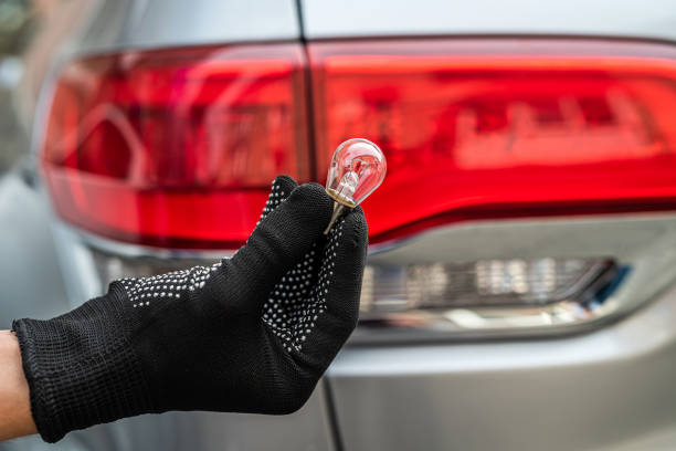 istock manual worker is changing a light bulb of the car 1360007201