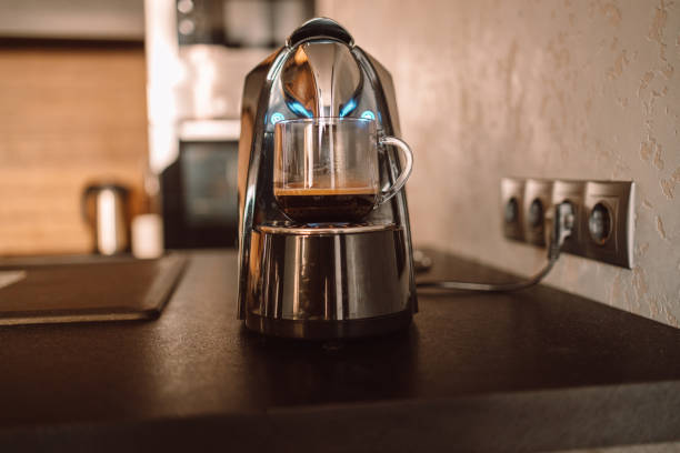 istock Cozy home desk table with modern coffee machine, glass of cup. Breakfast 1360007252