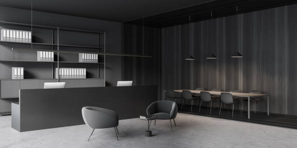 istock Dark reception interior and desk with computer and shelf, table with chairs 1360007622
