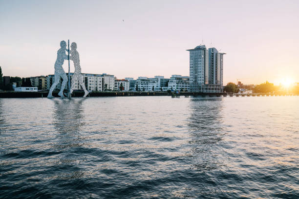 Popular landmark called the "Molecule Men" in Berlin, Germany Berlin, Germany - September 14, 2021:  Molecule Man sculpture by Jonathan Borofsky. The sculpture represent the intersection of the districts Treptow, Kreuzberg and Friedrichshain. Sunset view. friedrichshain photos stock pictures, royalty-free photos & images