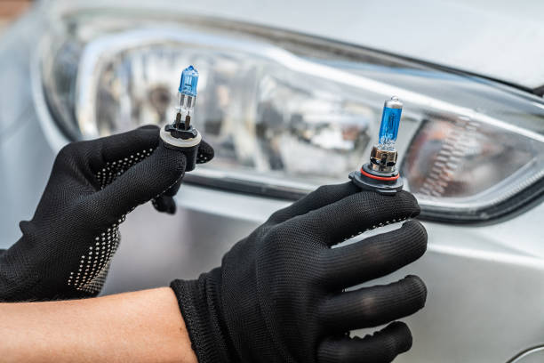 istock manual worker is changing a light bulb of the car 1360007985