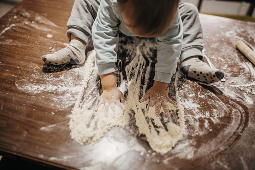 Boy in the kitchen, playing with flour