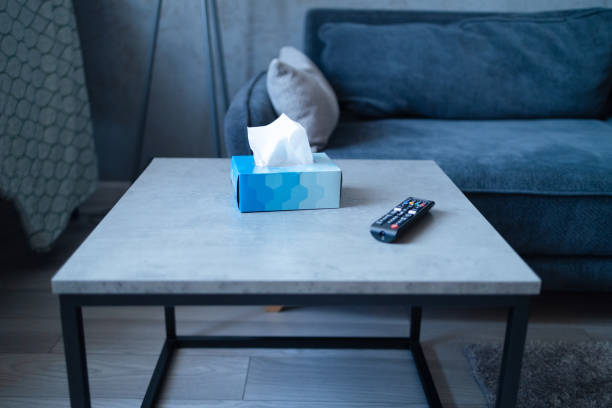 Blue tissue box on the bedside table in the bedroom, minimalism in the interior Blue tissue box with remote controller on the bedside table in the bedroom, minimalism in the interior. remote control on table stock pictures, royalty-free photos & images