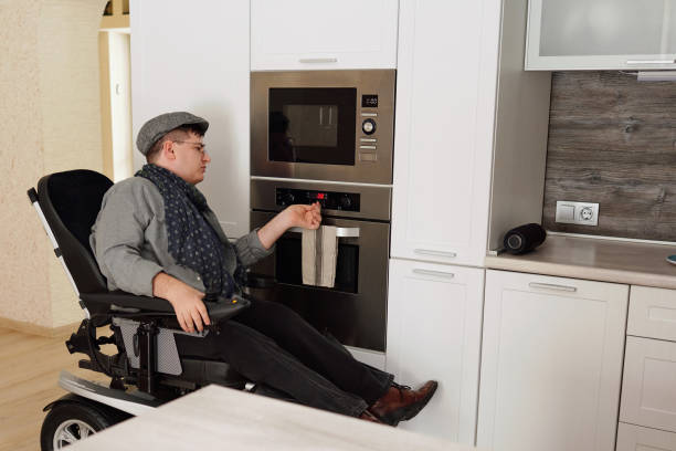 istock Man with disability checking timer on electric oven while cooking food 1360009051