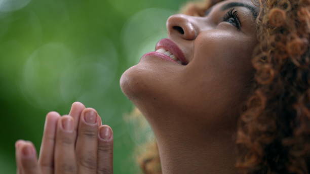 Happy Brazilian woman worshipping God looking up at sky smiling stock photo