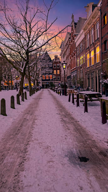 schneebedecktes amsterdam im winter in den niederlanden bei sonnenuntergang - waterdam stock-fotos und bilder