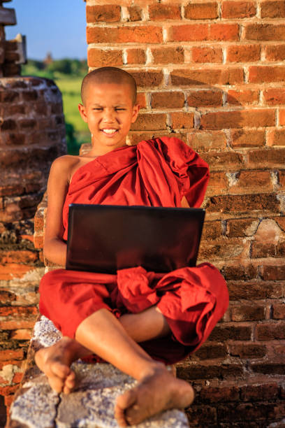 jeune moine bouddhiste utilisant l'ordinateur portatif, bagan, myanmar - hinduism monk buddhism myanmar photos et images de collection