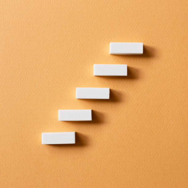 istock Stairs block on orange background. Growth and challenge concept 1360014741