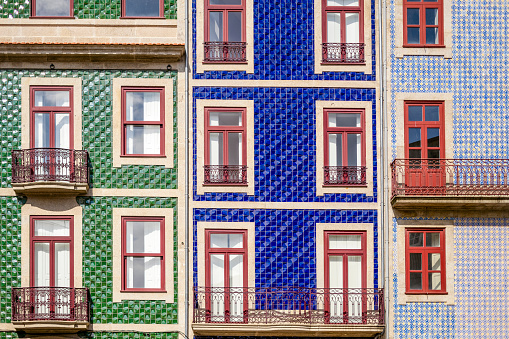 Three tenant houses covered with typical colorful tiles in Porto, Portugal