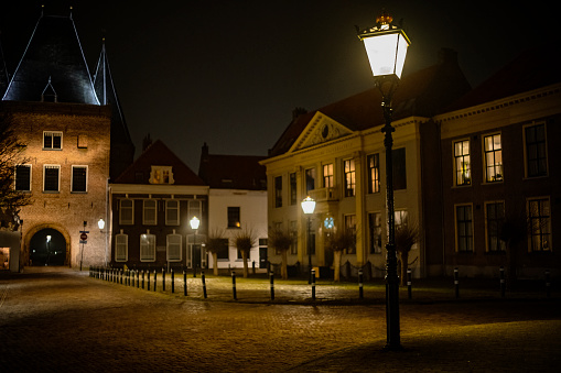 Koornmarktssquare and Koornmarktspoort in the old town of Kampen in Overijssel, The Netherlands during a cold winter night.