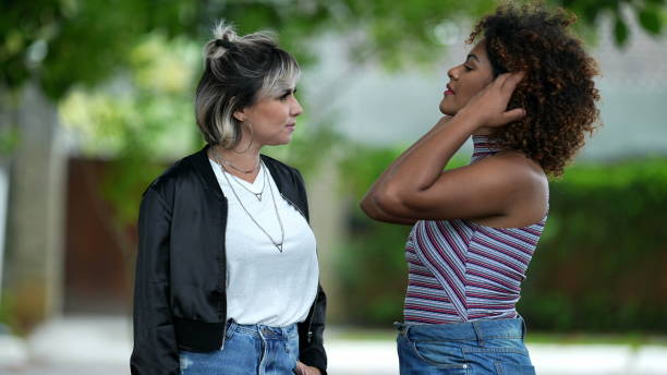 istock Two diverse friends talking outside at park. people conversation 1360018450