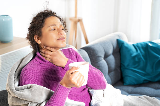 Portrait of black woman suffering tonsillitis at home Portrait of black woman suffering sore throat at home sore throat stock pictures, royalty-free photos & images