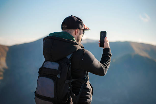 istock Tourist takes on smartphone mountain scenery 1360020180