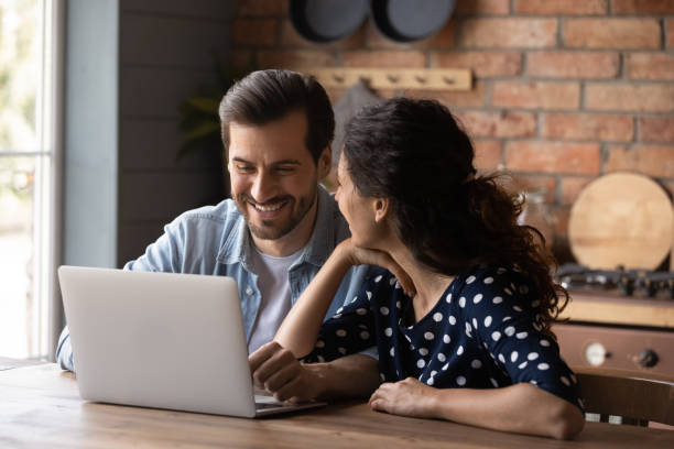 istock Cheerful emotional young family couple using computer. 1360022026