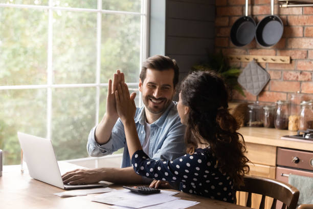 jeune couple familial heureux célébrant un investissement réussi. - utility payments photos et images de collection