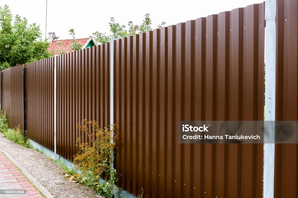 Closeup Of A Brown Metal Profile Fence Corrugated Surface Copy Space closeup-of-a-brown-metal-profile-fence-corrugated-surface-copy-space