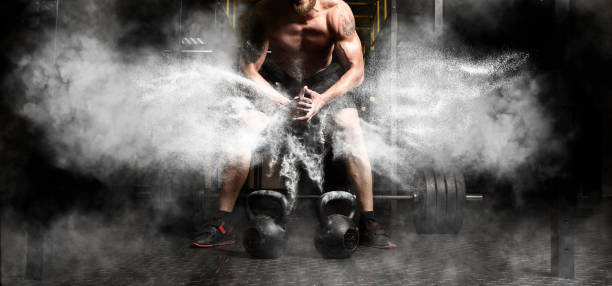 Muscular man workout with kettlebell at gym Muscular man clapping hands and preparing for workout at a gym crossfit chalk weightlifting weight training stock pictures, royalty-free photos & images