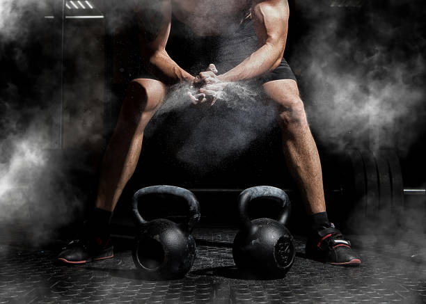 Weightlifter clapping hands and preparing for workout at a gym Weightlifter clapping hands and preparing for workout at a gym. Focus on dust cross training stock pictures, royalty-free photos & images