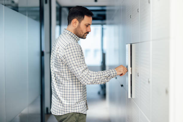 istock Concentrated caucasian man, preparing for work after puting his stuff in the locker. 1360024085