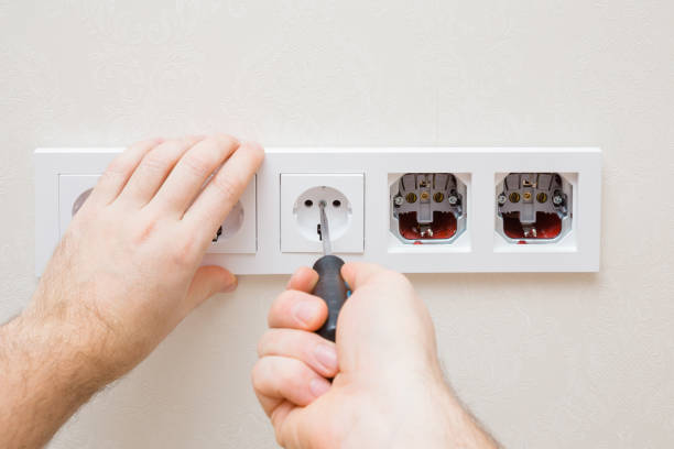 istock Young adult man hands holding screwdriver, screwing and installing new wall socket in white plastic frame. Closeup. Renovation process. Repair work of home. Point of view shot. 1360025005